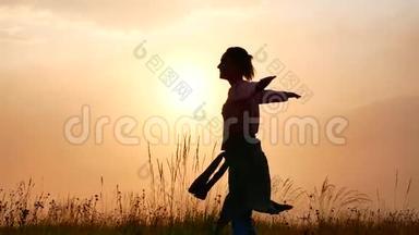 一个年轻的女人在山上日出时旋转。